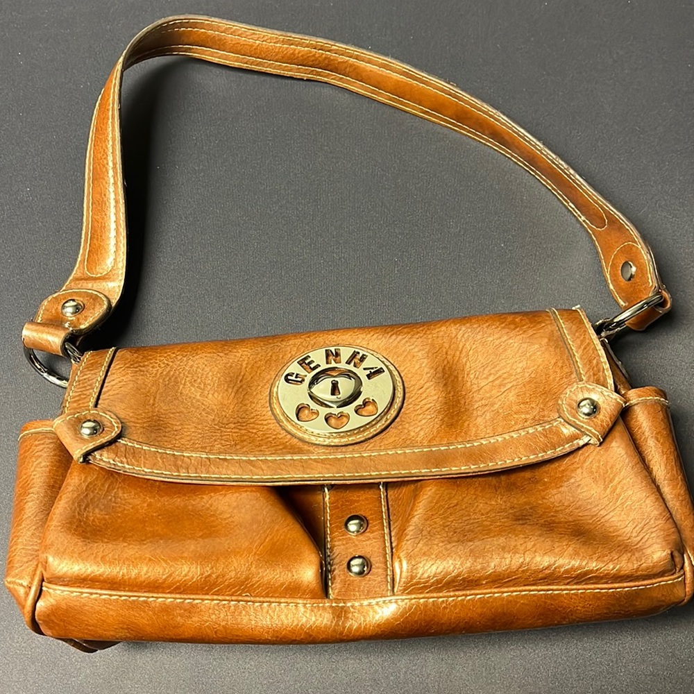 Genna metallic rust color shoulder bag with side pockets.